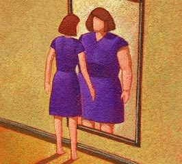 woman looking in mirror imagining her flaws